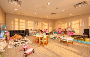 A children's playroom with a black leather sofa, play tables, and various toys. - New 2025 Luxury Stadium views/Downtown Core (Vancouver)