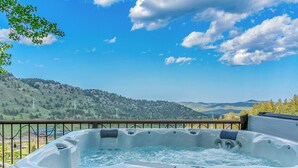 A hot tub with a view of a mountainous landscape.