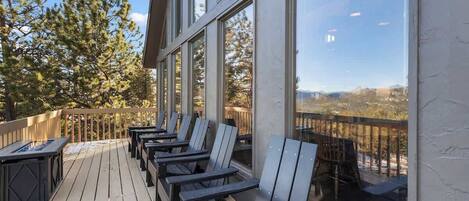 A deck with outdoor seating and a view of the landscape.