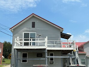 Un immeuble de deux étages doté d’un balcon et d’un toit rouge.