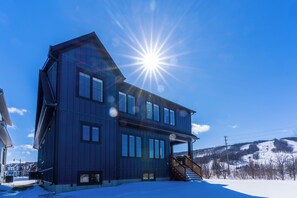 A two-story house with a balcony and a staircase leading to the entrance. - Bright, spacious, amazing view at a prime location (The Blue Mountains)