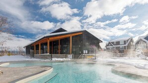 A pool area with a building featuring large windows and a covered patio. - Bright, spacious, amazing view at a prime location (The Blue Mountains)