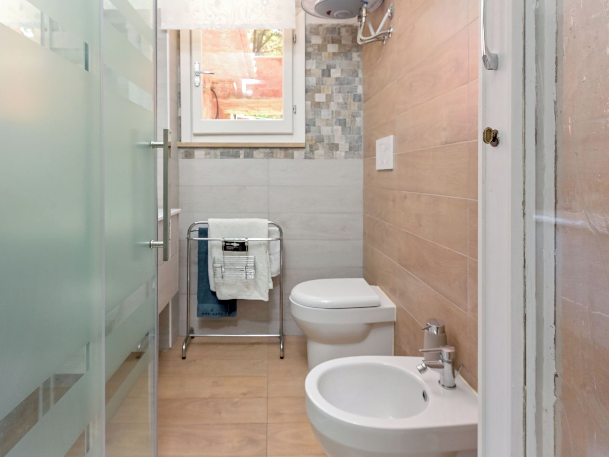 A modern bathroom with a glass shower enclosure, a toilet, and a sink.