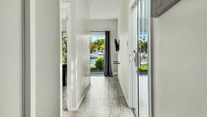 A hallway with a view of a marina, a small step, and a TV mounted on the wall.