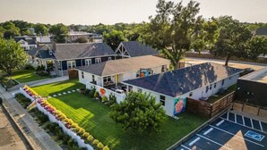 A building with a parking lot and a green lawn with flower beds.