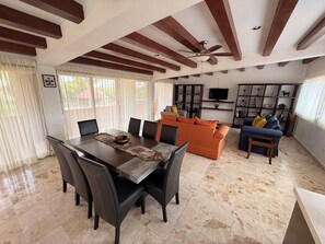 A spacious living area with a dining table, sofas, and a TV. - Ranch with 3-bedrooms and phenomenal natural spaces in Baca Yucatán México (Baca)