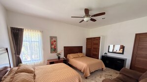 A bedroom with two beds, a ceiling fan, a wardrobe, a desk, and a chair. - Ranch with 3-bedrooms and phenomenal natural spaces in Baca Yucatán México (Baca)
