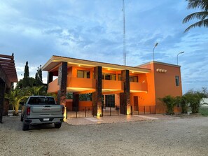 A modern two-story building with a prominent entrance and a visible sign. - Ranch with 3-bedrooms and phenomenal natural spaces in Baca Yucatán México (Baca)