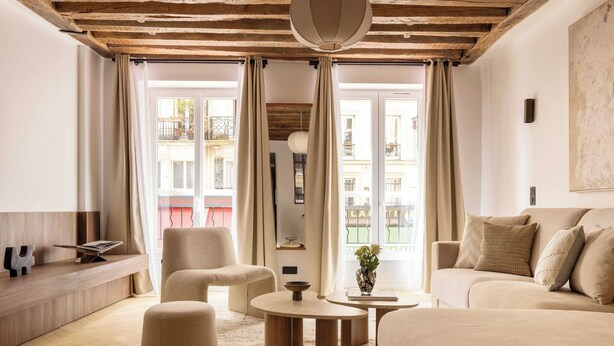 Una sala moderna con un sofá, sillones, una mesita de centro y una estantería.