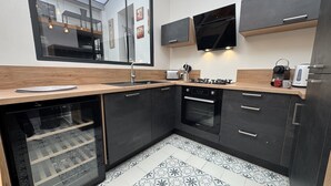 Een moderne keuken met donkere kastjes, een inbouwoven, een magnetron en een gasfornuis.
