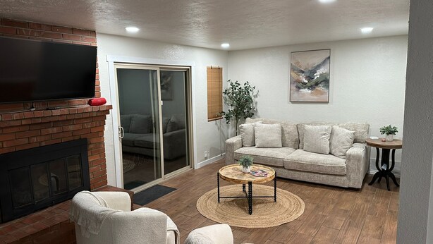 Una sala de estar con chimenea, un sofá, una mesa de centro y un televisor.