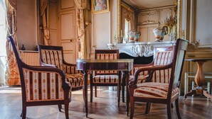 A room with ornate furniture, including a fireplace with a mirror and candle holders, and a patterned rug. - Countryside Castle With Concierge Luxury (Maigné)