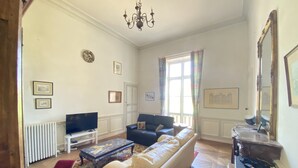 A living room with a sofa, a television, a coffee table, and a patterned rug. - Countryside Castle With Concierge Luxury (Maigné)