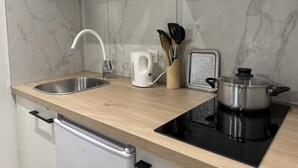 A modern kitchen with a stainless steel sink, a built-in stove, and a microwave. - Modern Comfort in the Heart of Le Mans (Le Mans)