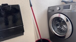 Ein Waschbereich mit Waschmaschine und Wischbottich.