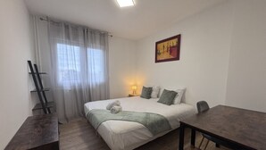 Ein Schlafzimmer mit einem Bett, einem Nachttisch, einer Lampe und einem Bild an der Wand.