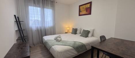 Une chambre à coucher avec un lit, une table de chevet, une lampe et un tableau au mur.