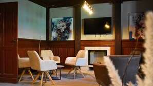 A lobby with a fireplace, multiple seating areas, and artwork on the walls.