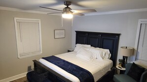 A bedroom with a bed, a ceiling fan, a nightstand, a chair, and a lamp. - Charming 3-bedroom house with AC, WiFi in fabulous Mobile (Mobile)