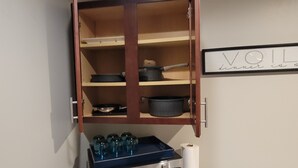 A kitchen with a microwave, a cabinet with pots, and a roll of paper towels. - Charming 3-bedroom house with AC, WiFi in fabulous Mobile (Mobile)