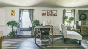 Un espace repas comprenant une table, des chaises et donnant sur l’extérieur.