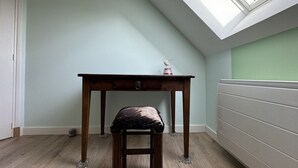 Une pièce dotée d’une lucarne, d’une table en bois avec un coussin, et d’un radiateur.