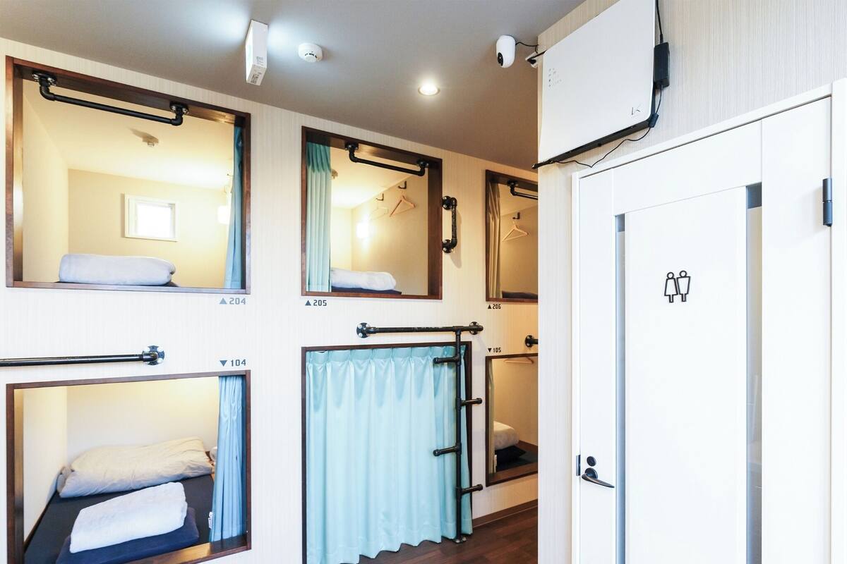 Ett hotellrum med våningssängar, ett badrum och en garderob.
