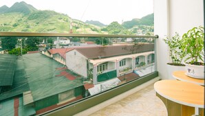 Un balcón con vistas a un pueblo y colinas.