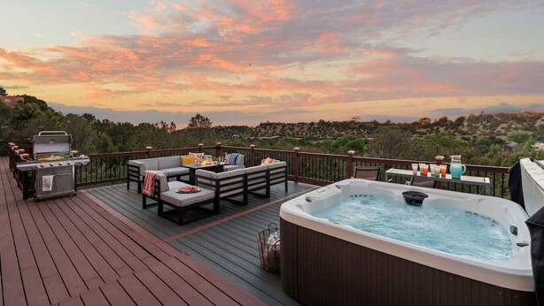 Una terrazza con idromassaggio, posti a sedere all'aperto e barbecue.