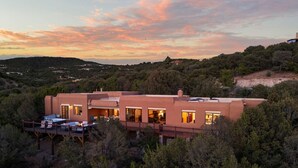 Una casa moderna con diverse stanze, una terrazza e vista sulla foresta circostante.