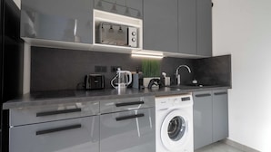 Une cuisine moderne équipée d’un lave-linge intégré, d’un four à micro-ondes et d’un évier.