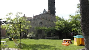 Un edificio de piedra con un jardín delantero.