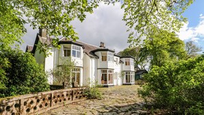 A large, white, two-story house with a stone pathway leading to the entrance. - Camisky Lodge (Fort William)