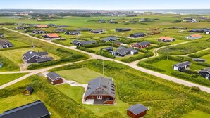 Eine Vogelperspektive eines Wohngebiets mit Häusern, Straßen und grünen Feldern.