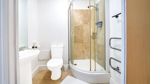 A modern bathroom with a glass-enclosed shower, a toilet, and a sink. - GO2 Gloucester Hotel by OYO | Standard Double (Gloucester)