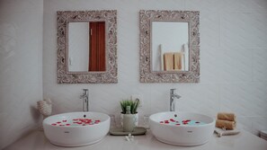 A bathroom with two white sinks, each with a mirror above. There are decorative vases and a small plant on the counter. - Genta Villa Ubud (Ubud)