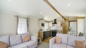 A compact living space with two sofas, a kitchenette, and a small dining area. - Caravan with one double and two twin. (Longridge, Ribble Valley)
