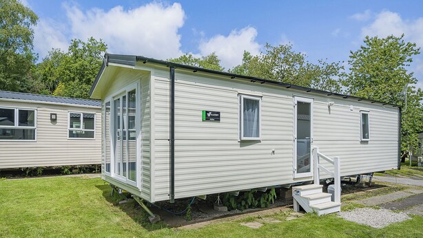 A mobile home with a front door, a small window, and a ramp leading to the entrance. - Caravan with one double and two twin. (Longridge, Ribble Valley)