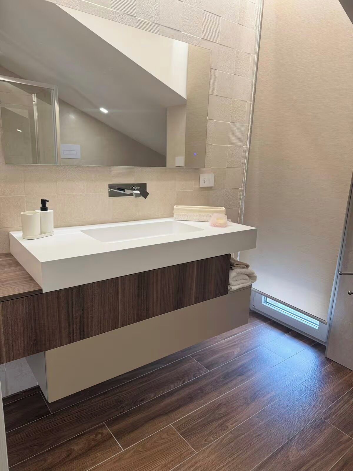 A modern bathroom with a large sink, a mirror, and a heated floor.