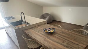 Une cuisine moderne avec une table à manger en bois, deux chaises, un évier et une cuisinière.