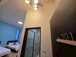 A hotel room with two beds, a shower, and a ceiling fan. - Six Kids Family B&B  (Gongguan)