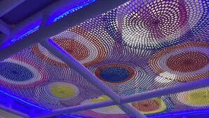 Une structure de jeu dotée d’un design circulaire et coloré en forme de filet, ainsi que d’un toboggan.
