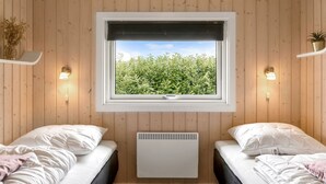 A room with two beds, a window with a view of greenery, and wall-mounted lights. - "Naimi" - 30km from the sea by Interhome (Toftlund)