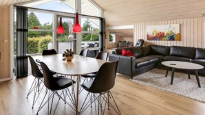 A modern living room with a dining area, featuring a large table and chairs, a leather sofa, and a painting on the wall. - "Naimi" - 30km from the sea by Interhome (Toftlund)
