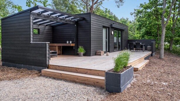 A modern, two-story cabin with a deck, built-in seating, and a pergola. - "Konrad" - 300m from the sea by Interhome (Hals)