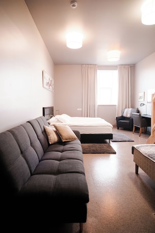 Escritorio, cortinas blackout y tabla de planchar con plancha