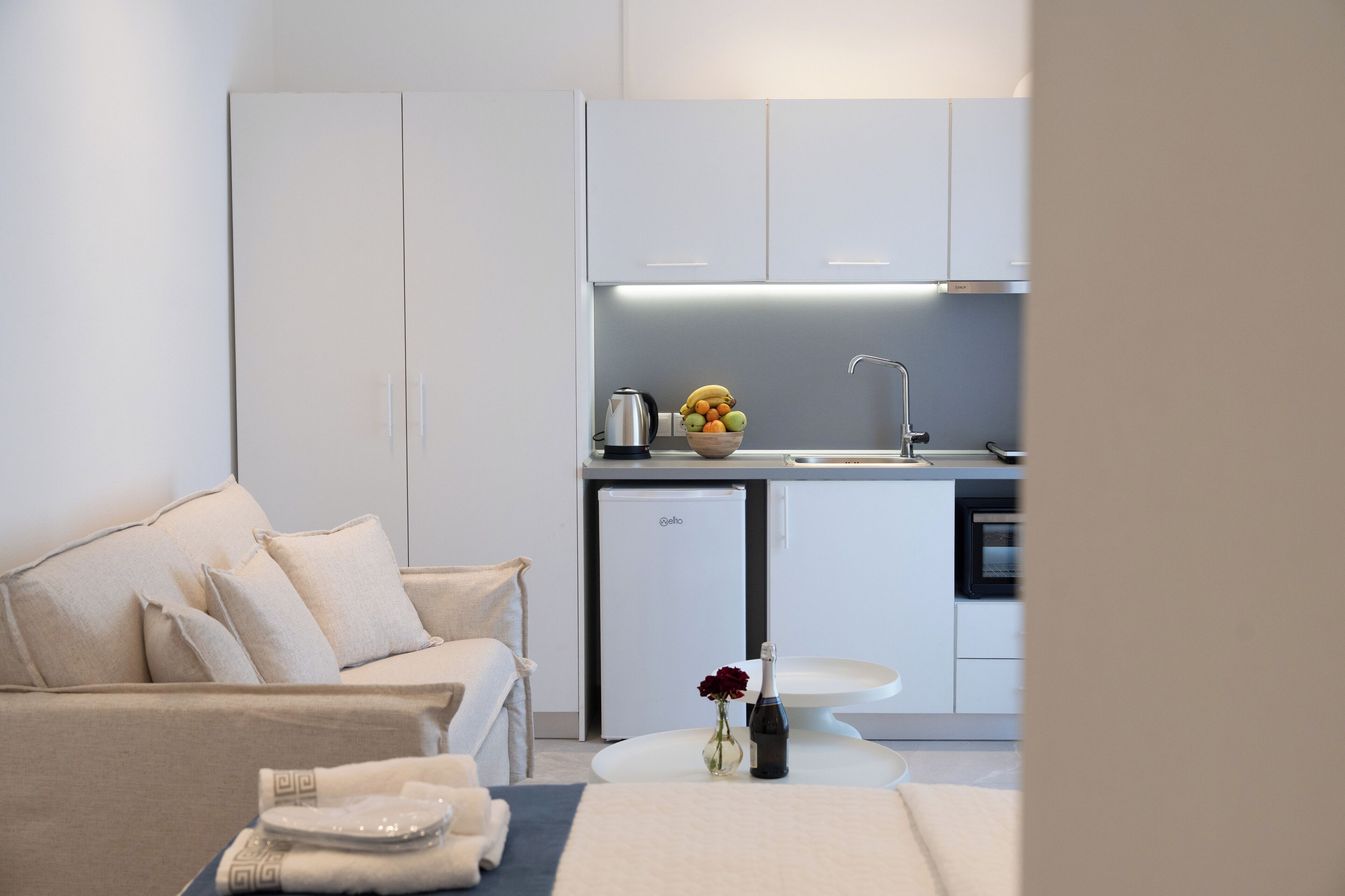 A modern, minimalist living room with a sofa and a small dining area.
