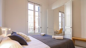 Una habitación de hotel con cama, escritorio y silla.