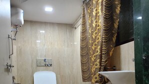 Un baño con inodoro, ducha y lavamanos.