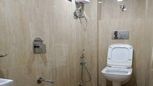 Un baño con inodoro, ducha y un cubo con la etiqueta 'JOYO'.